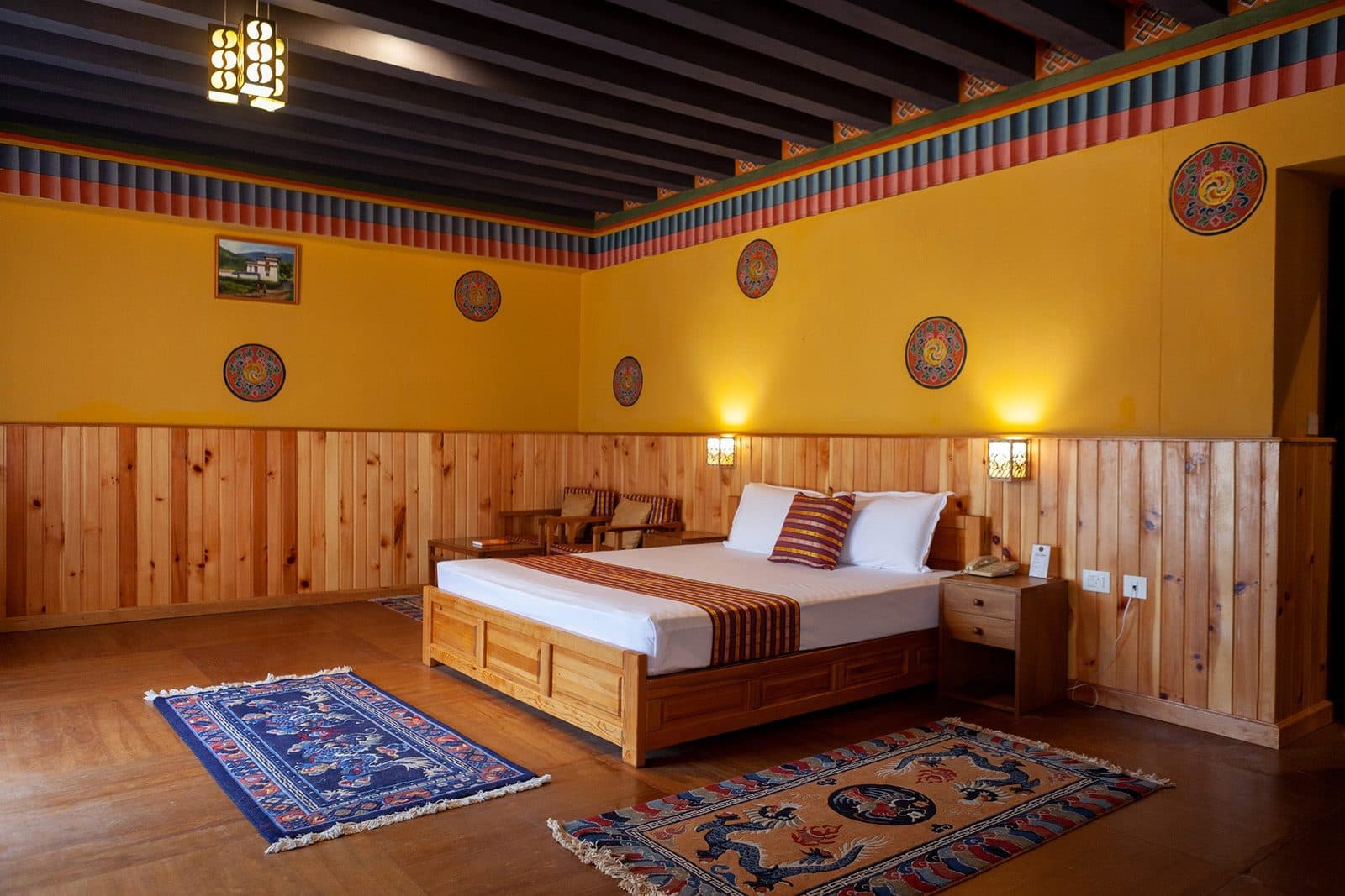 Wood-panelled cottage bedroom with Bhutanese rugs