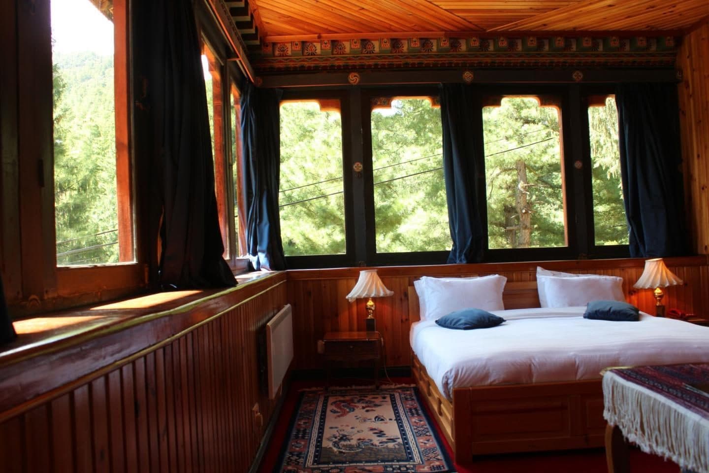 Cottage bedroom with wide windows onto the pines